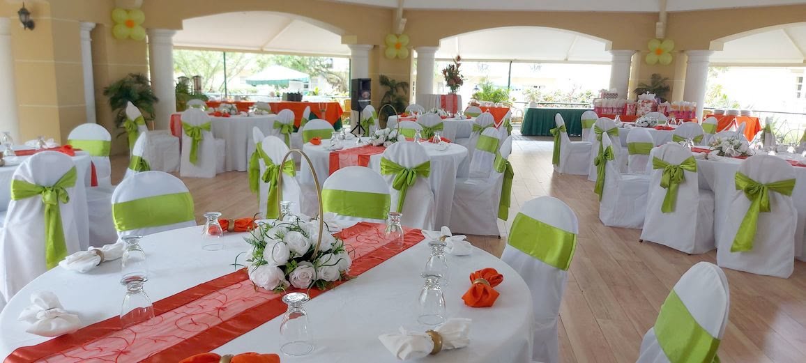Banquet tables with covered chairs and green tie-backs