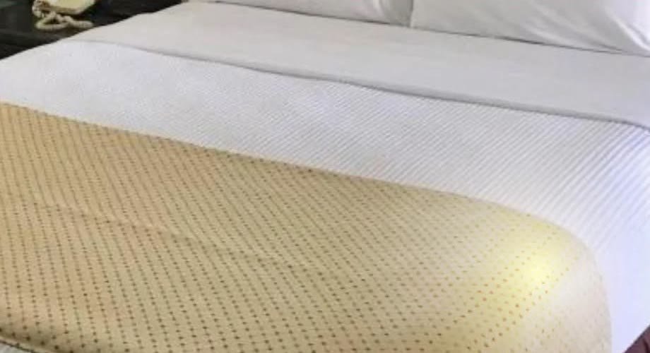 A made-up bed in a Royal Hotel standard room